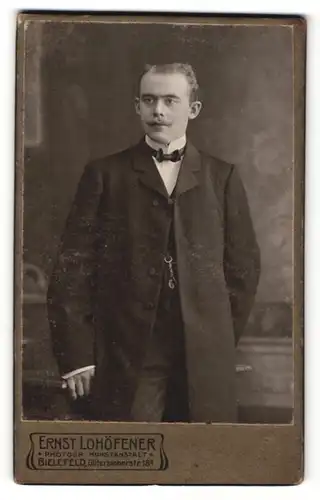 Fotografie Ernst Lohöfener, Bielefeld, Portrait elegant gekleideter Herr mit Fliege und Schnurrbart