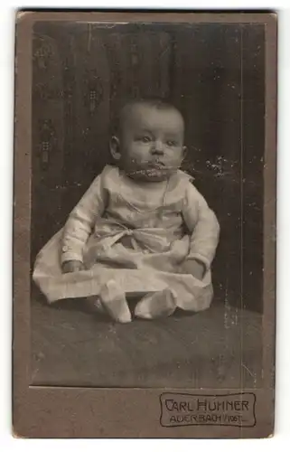 Fotografie Carl Hühner, Auerbach i / Vogtl., Portrait niedliches Baby im hübschen Kleid mit Schleife