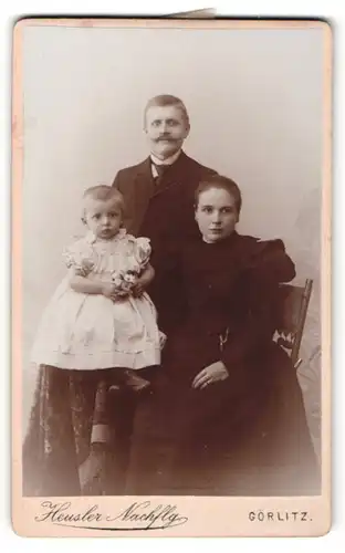 Fotografie Heusler Nachfolger, Görlitz, hübsche junge Familie in eleganter Kleidung