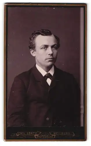 Fotografie Emil Görtz, Weilburg, Portrait junger Mann mit lockigem Haar im Anzug