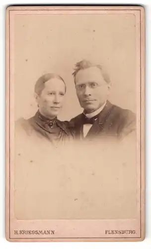Fotografie H. Kriegsmann, Flensburg, Portrait bürgerliches Paar in zeitgenössischer Kleidung