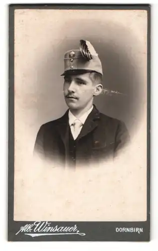 Fotografie Alb. Winsauer, Dornbirn, Portrait junger Herr im Anzug mit Krawatte und Schirmmütze