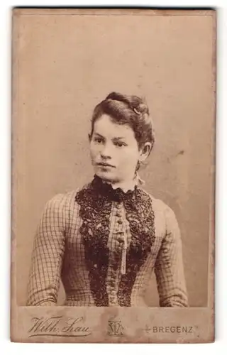 Fotografie Wilh. Lau, Bregenz, Portrait junge Dame im karierten Kleid mit Spitzenkragen