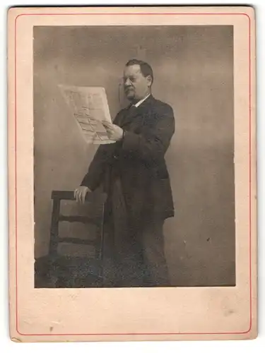 Fotografie Edelmann im Anzug mit Zwicker liest Zeitung
