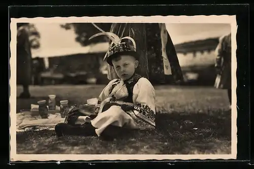 AK Kleiner Junge in tschechischer Tracht neben einer Picknickdecke