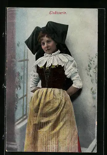 AK Elsässerin in Tracht lehnt lässig an der Wand