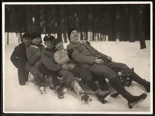 Fotografie Rodeln, Quintett gemeinsam auf einem Schlitten im Schnee