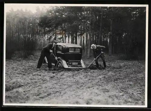 Fotografie Männer befreien festgefahrenes Auto aus dem Morast, Kfz-Kennzeichen IV-18836