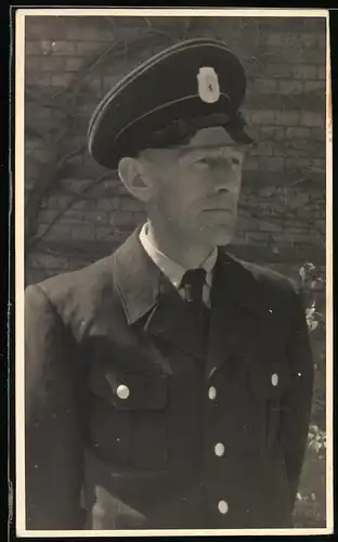 Fotografie Polizei Berlin, Polizist in Uniform mit Schirmmütze