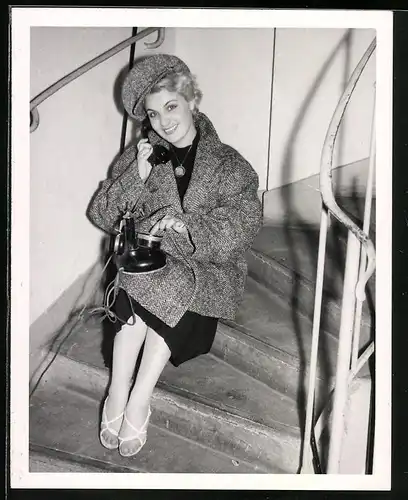 Fotografie hübsche Frau im modischen Herbst-Outfit mit Telefon, Telefonapparat im Treppenhaus
