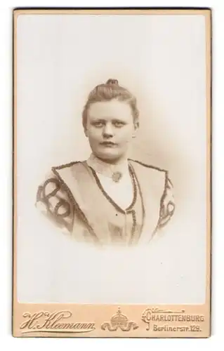 Fotografie H. Kleemann, Berlin-Charlottenburg, Berlinerstrasse 129, Blonde junge Dame mit Dutt und Brosche