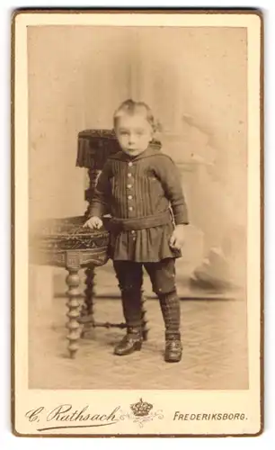 Fotografie C. Rathsach, Frederiksborg, Kleiner Junge im gegürteten Hemd mit kurzer Hose und Kniestrümpfen