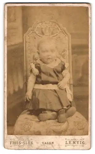 Fotografie Friis-Slök, Lemvig, Vasen, Kleinkind im kurzärmeligen Kleidchen auf einem Stuhl