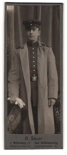 Fotografie G. Sauer, Wittenberg, Jüdenstrasse 10, Junger Soldat in Uniformmantel und Schirmmütze