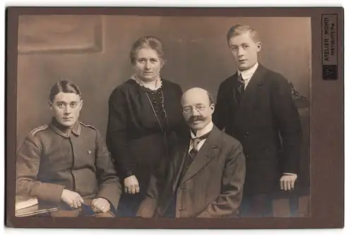 Fotografie Atelier Mohn, Nienburg a. W., Junger Uffz. mit Orden in Uniform mit seiner Familie