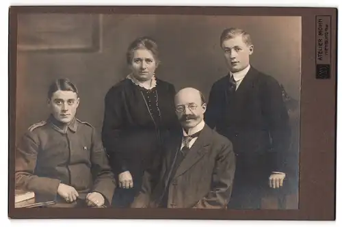 Fotografie Atelier Mohn, Nienburg a. W., Junger Uffz. in Uniform mit Eltern und Bruder