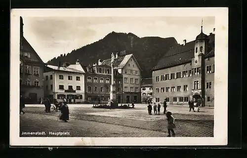 AK Immenstadt, Hauptplatz mit Säulendenkmal und Passanten