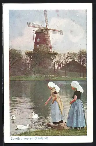 AK zwei Mädchen in niederländischer Tracht füttern Enten