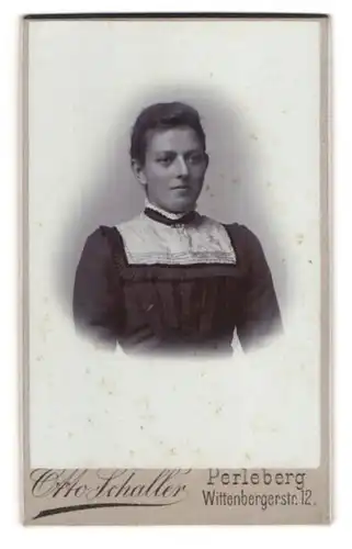 Fotografie Otto Schaller, Perleberg, Wittenbergerstr. 12, Junge Dame in tailliertem dunklem Kleid mit schmalen Lippen