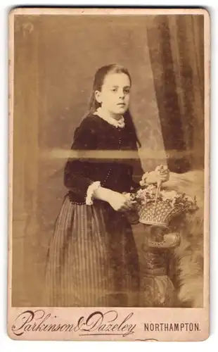 Fotografie Parkinson & Dazeley, Northampton, Gold St. 37, Junge Dame in schwarzer Jacke mit Blumenkorb und langen Haaren