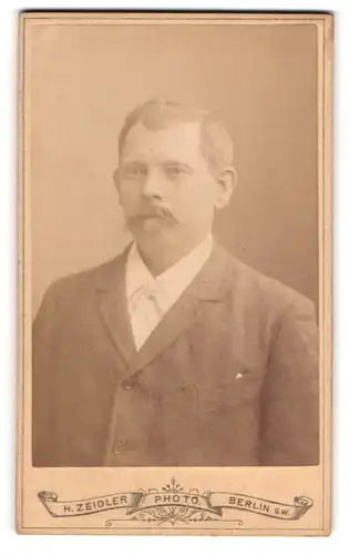 Fotografie H. Zeidler, Berlin, Jerusalemerstr. 59, Herr in dunklem Anzug mit grossen Ohren und Schnurrbart