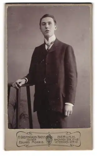 Fotografie Eduard Morris, Berlin, Brunnenstr. 17, Junger Mann in schwarzem Anzug mit weissem Hemd und hohem Kragen