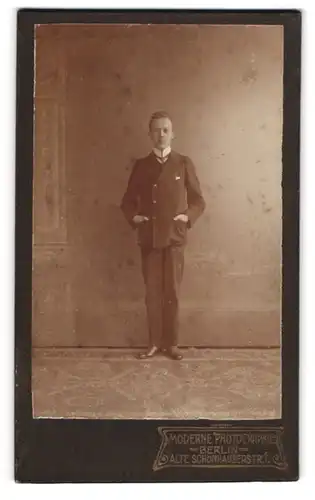 Fotografie Fotograf unbekannt, Berlin, Alte Schönhauserstr. 1, Junger Mann im Anzug mit Krawatte und am Lächeln
