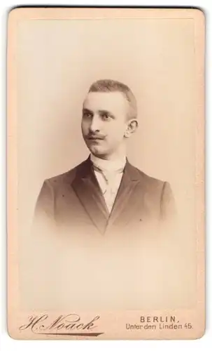 Fotografie H. Noack, Berlin, Unter den Linden 45, Junger Mann mit Schnurrbart im dunklen Anzug mit heller Krawatte