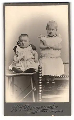 Fotografie H. P. Dannemand, Aarhus, Ryasgade 16, Niedliche Kleinkinder in weissen Kleidern mit Herzkette