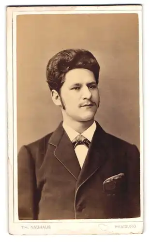 Fotografie Th. Nauhaus, Hamburg, Steinstr. 136, Junger Mann im dunklen Anzug mit Koteletten und Schnurrbart