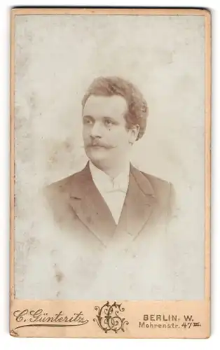 Fotografie C. Günteritz, Berlin, Mohrenstr. 47, Herr mit Schnurrbart und Locken in weissem Hemd und dunklem Anzug