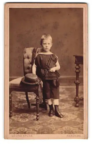 Fotografie Georg Kruse, Randers, Vestergade 39, Süsser blonder Junge posiert ganz lässig mit Hut vor der Kamera