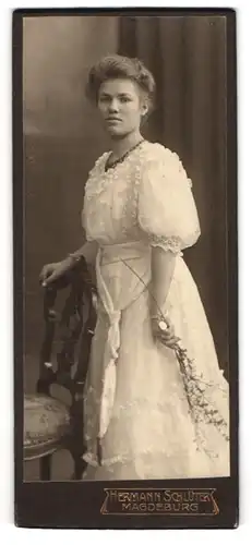 Fotografie Hermann Schlüter, Magdeburg, Gutaussehende junge Frau mit Kette im eleganten weissem Kleid
