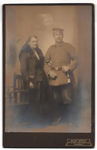 Fotografie Kurt Böhm, Passau, Soldat in Uniform mit Portepee am Bajonett mit seiner Frau im Arm