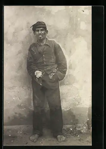 Foto-AK Bettler an einer Hauswand hält seine missgebildete Hand auf