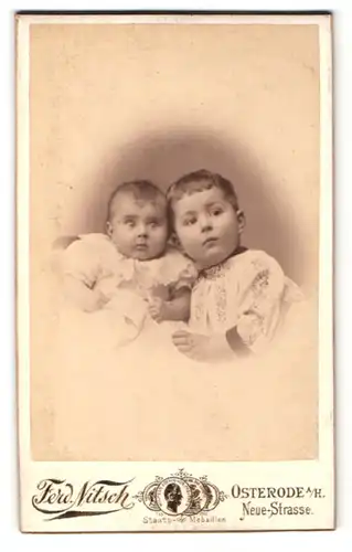 Fotografie Ferd. Nitsch, Osterode, Portrait zwei süsses Kleinkinder in Kleidern