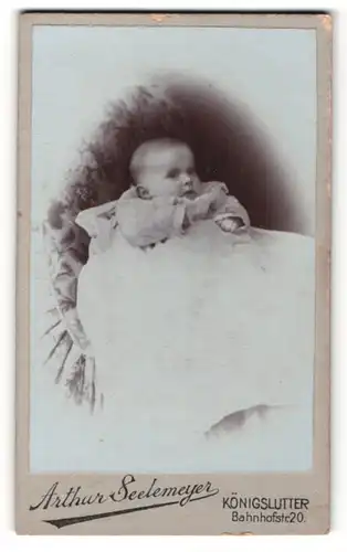 Fotografie Arthur Seelemeyer, Königslutter, Portrait süsses Baby im weissen Kleidchen