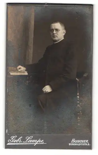 Fotografie Gebr. Lampe, Hannover, Portrait Geistlicher mit Brille und Buch