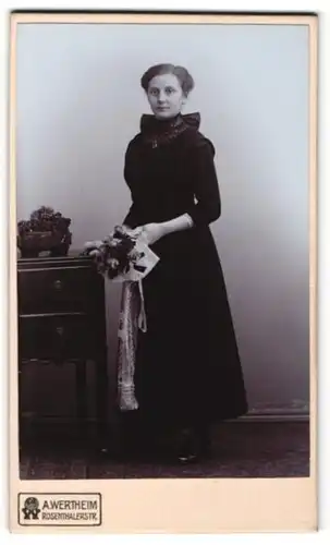 Fotografie A. Wertheim, Berlin, Portrait bürgerliche Dame mit Blume an Kommode gelehnt