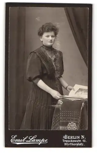 Fotografie Emil Lampe, Berlin-N, Portrait bürgerliche Dame mit Zeitung an Tisch gelehnt