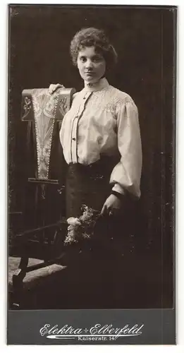 Fotografie Elektra, Elberfeld, Portrait junge Dame in hübscher Bluse mit Blumen an Stuhl gelehnt