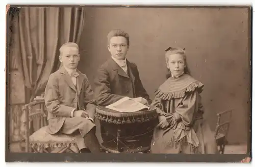 Fotografie Hans Ohrner, Blumenthal i/Han., Zwei Burschen und ein Mädchen sitzen an einem runden Tisch