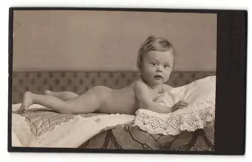 Fotografie Ludwig Schindhelm, Ebersbach i. S., Portrait nacktes süsses Kleinkind auf einem Fell liegend