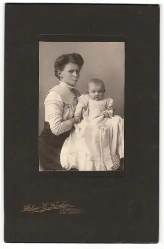 Fotografie E. Fischer, Zwenkau, Portrait hübsch gekleidete Dame mit Baby auf dem Arm