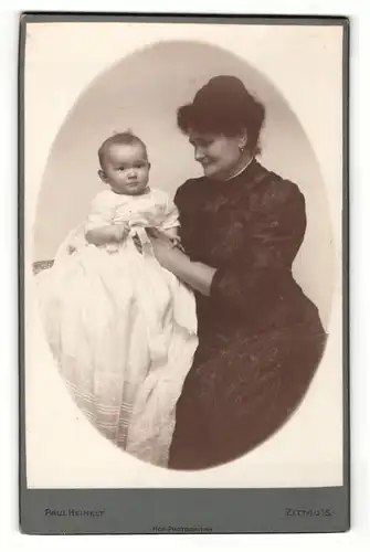 Fotografie Paul Heinelt, Zittau i. S., Portrait elegant gekleidete Dame mit Baby auf dem Arm