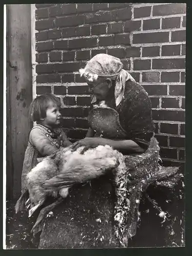 Fotografie Federreissen, Bäuerin rupft eine Gans mit der Enkeltochter 1938
