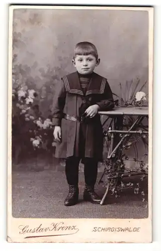 Fotografie Gustav Krenz, Schirgiswalde, Portrait kleiner Junge im Matrosenanzug am Tisch lehnend