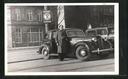 AK Mann steht neben seinem Auto auf einem Droschken-Parkplatz