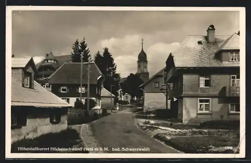 AK Höchenschwand /Schwarzwald, Strassenpartie mit Wohnhäusern und Blick zur Kirche