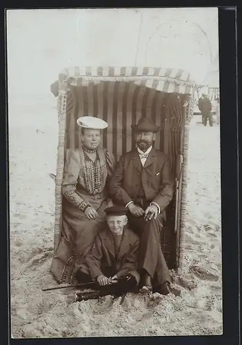 AK Elegant gekleidetes Ehepaar mit Sohn in einem Strandkorb